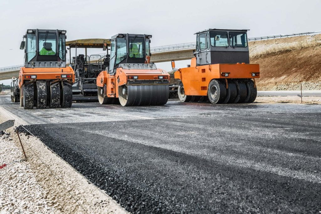Asphalt road construction with compactor vehicles